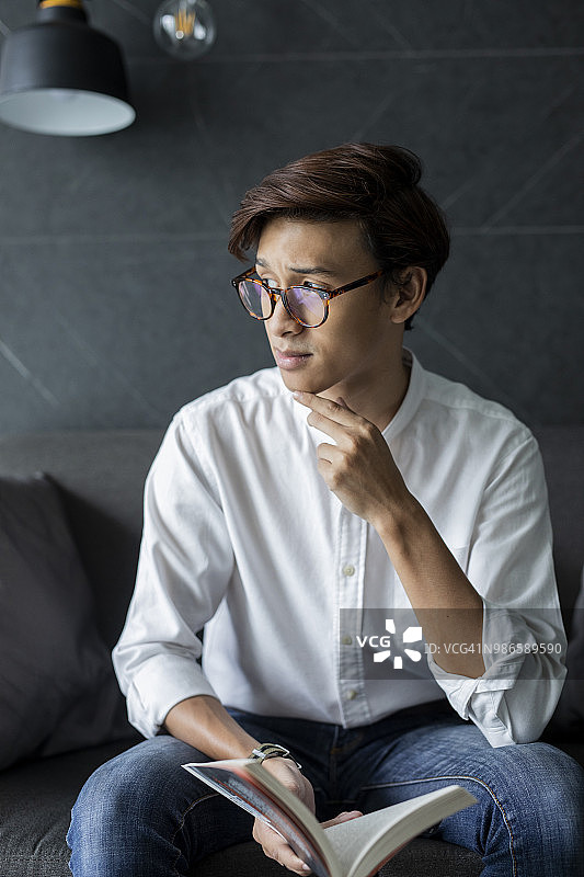 戴眼镜的男孩拿着一本书图片素材