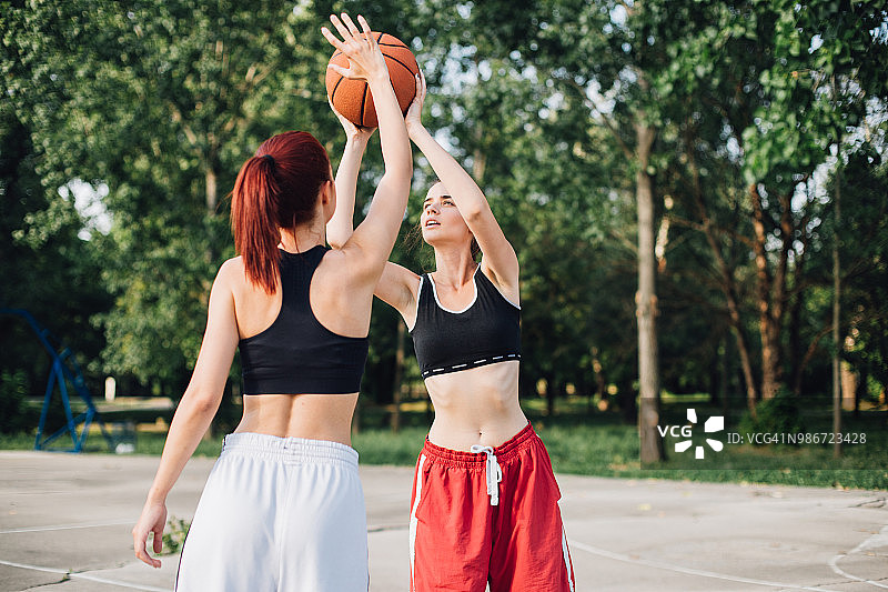 身穿运动服打篮球的疲惫女子图片素材
