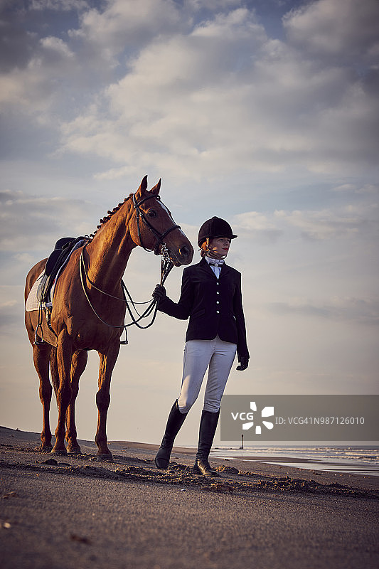 年轻女人与马在沙滩上图片素材