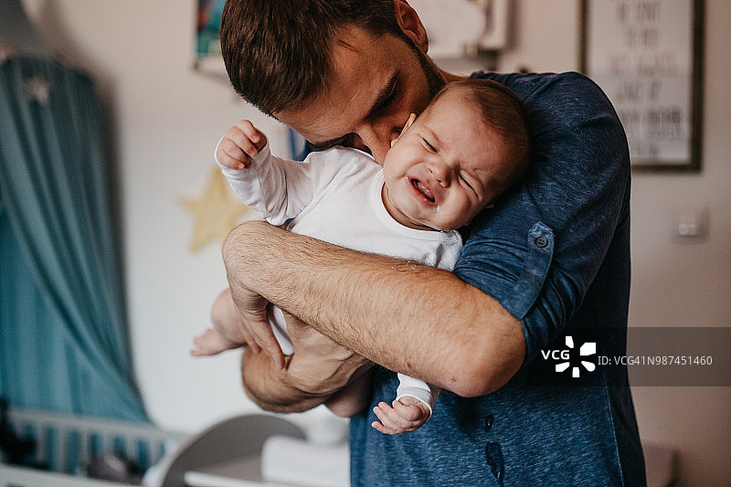 父亲拥抱哭泣的婴儿图片素材