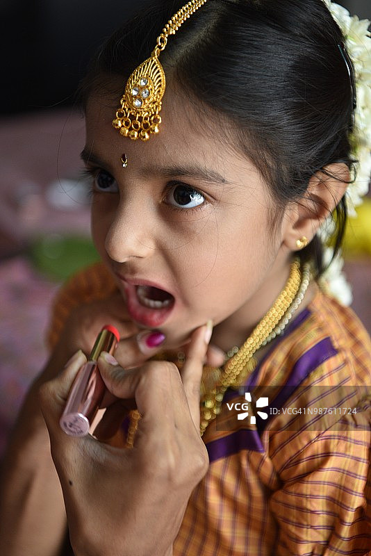 年轻女孩在后台涂口红图片素材
