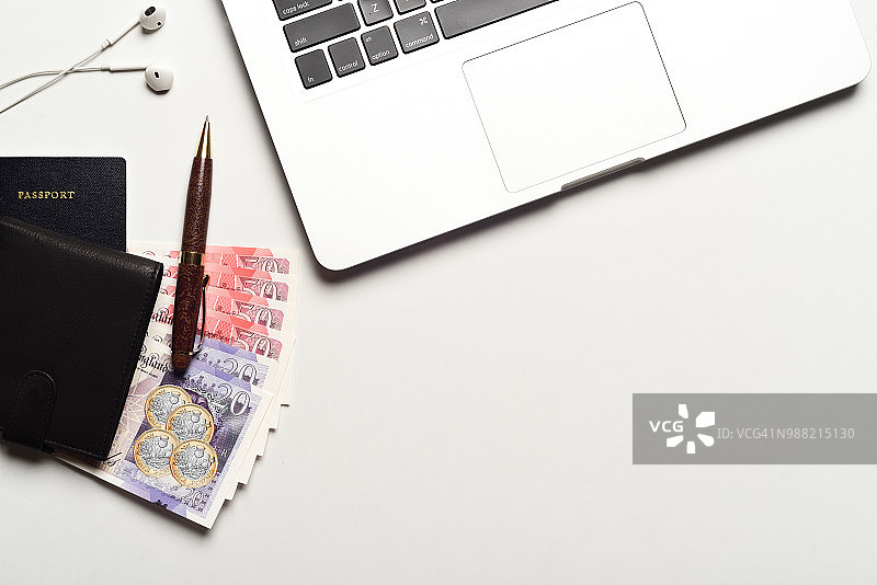 带有英镑、笔记本电脑、眼镜、记事本、笔和耳机的护照图片素材
