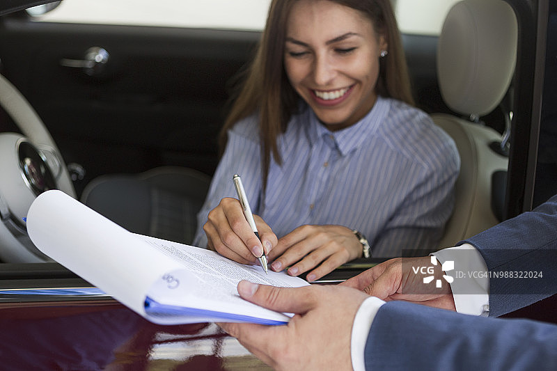 汽车销售员与客户签订合同，达成销售图片素材
