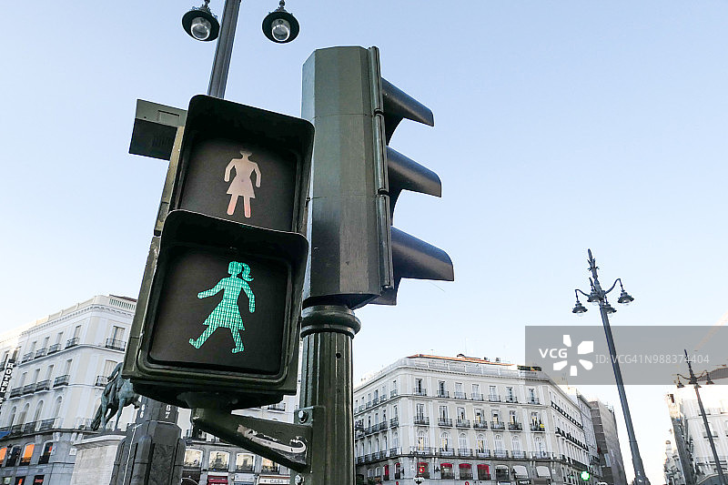 马德里城市中的女性行人与绿色交通灯图片素材