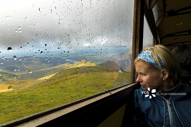 在斯诺登登山火车的车窗外眺望的中年妇女图片素材