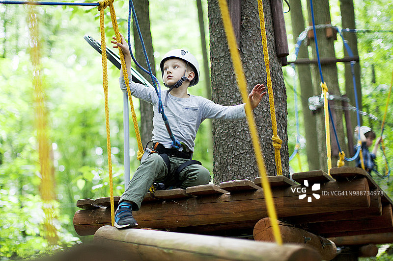 小男孩在绳索公园攀爬图片素材