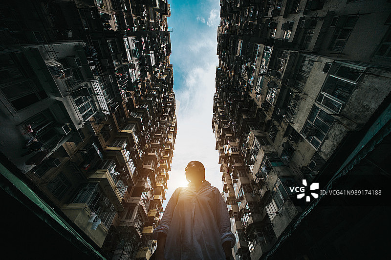 低角度视角下被城市中古老传统建筑环绕的女人，背景是晴朗的蓝天图片素材