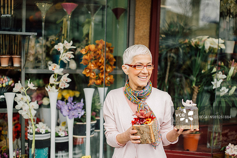 快乐的女销售员在花店前拿着鲜花图片素材