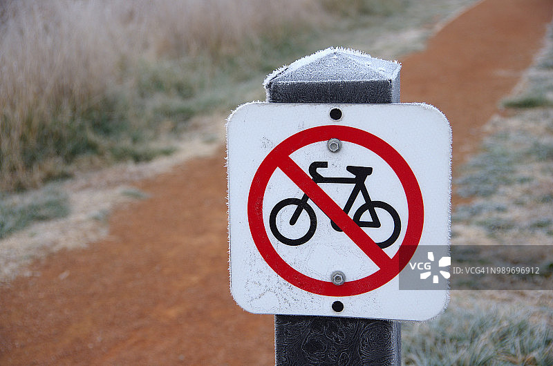 澳大利亚首都特区杰拉布姆伯拉湿地，泥泞小路旁的禁止自行车标志图片素材