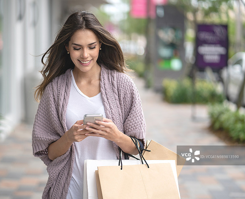 购物中的女人玩手机图片素材