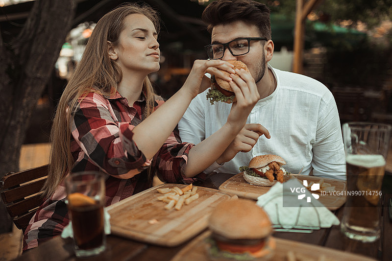 幸福情侣在户外享受美好的一天并享用汉堡图片素材