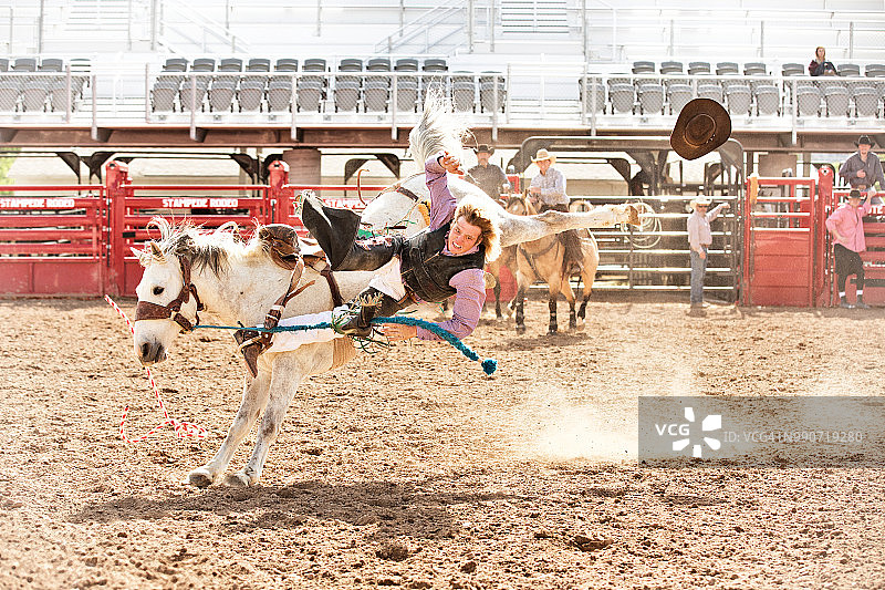 夏季牛仔竞技表演中，牛仔从无鞍野马背上摔落图片素材