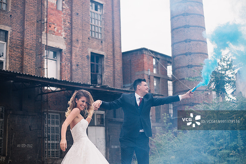 年轻夫妇在户外摆姿势，手持烟雾弹图片素材