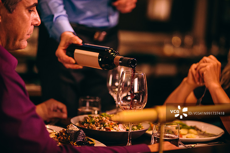侍酒师在晚餐前为品酒会服务红酒图片素材