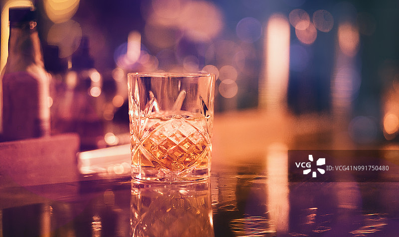 在酒吧的复古玻璃杯中供应的冰镇威士忌图片素材