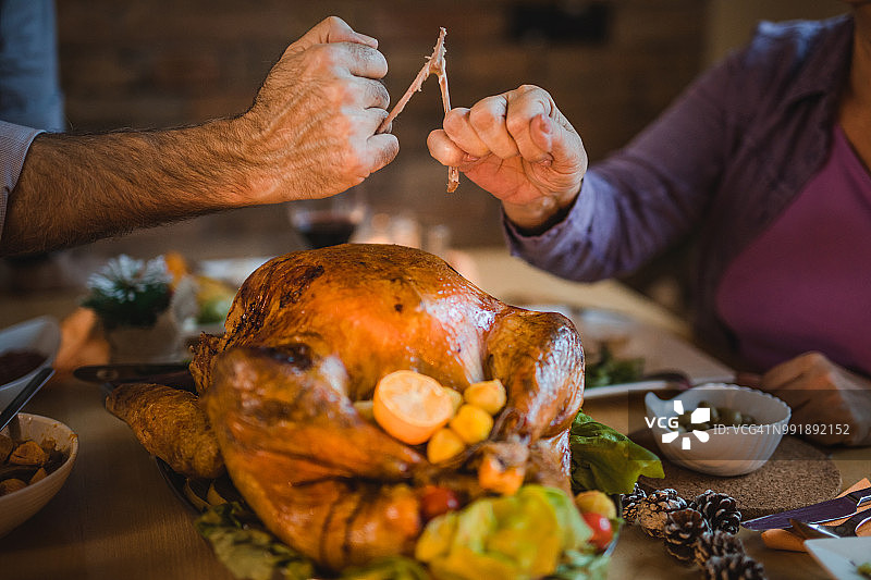 感恩节晚餐时，人们拉扯许愿骨图片素材