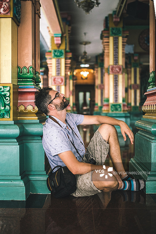 男人在斯里马哈马里亚曼兴都庙放松。图片素材