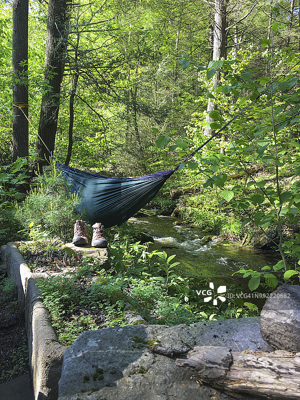小溪边的吊床和登山靴图片素材