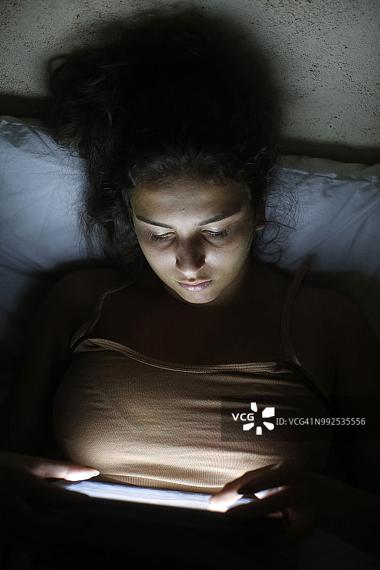 在意大利萨伦托夜晚使用平板电脑的19岁女子图片素材