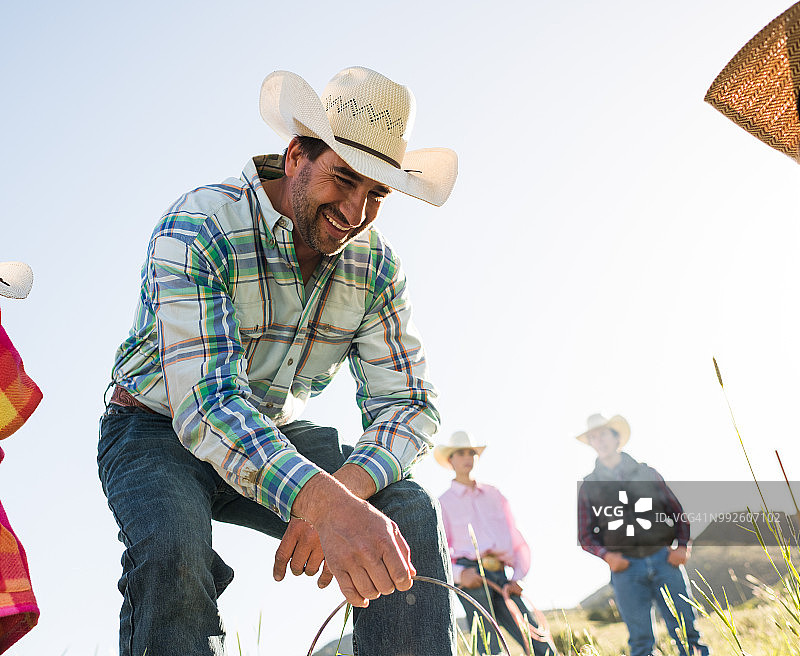 牛仔将荷兰烤箱放在火上的自然抓拍图片素材