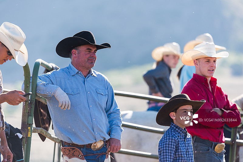 牧场主在围栏旁观看套牛图片素材