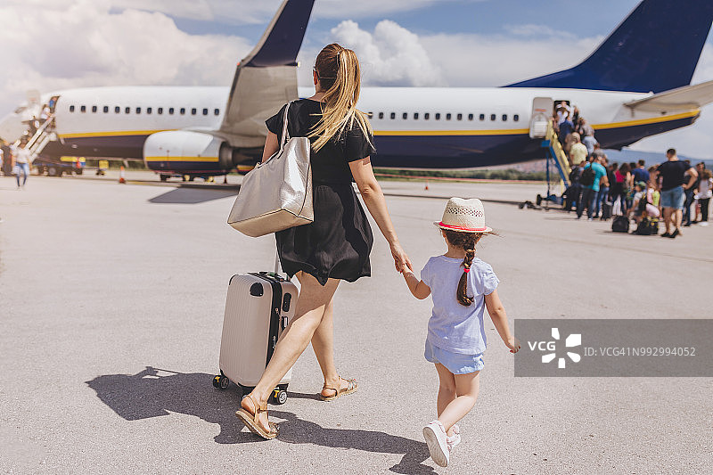 母女手牵手登上飞机图片素材