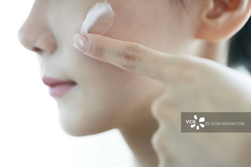 女人往脸上涂抹面霜图片素材