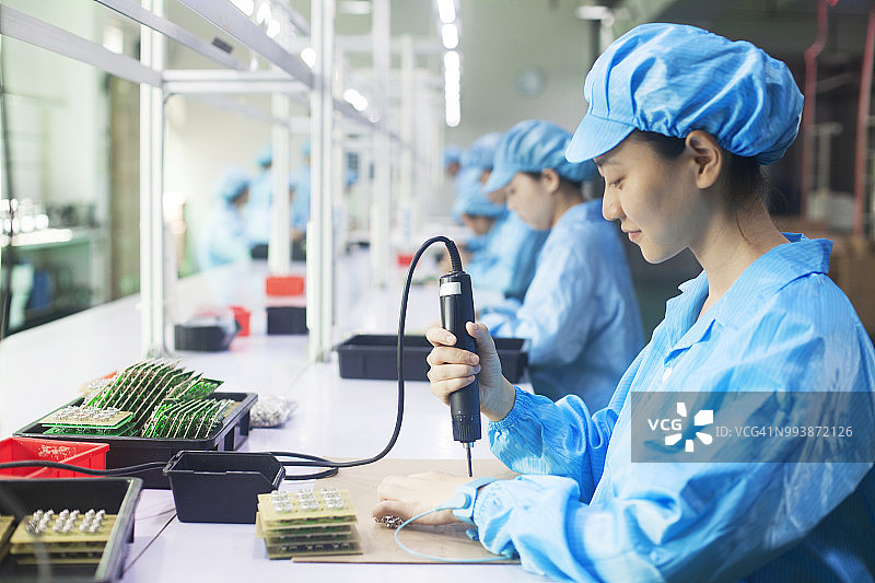 中国东莞LED灯具厂的制服工人图片素材