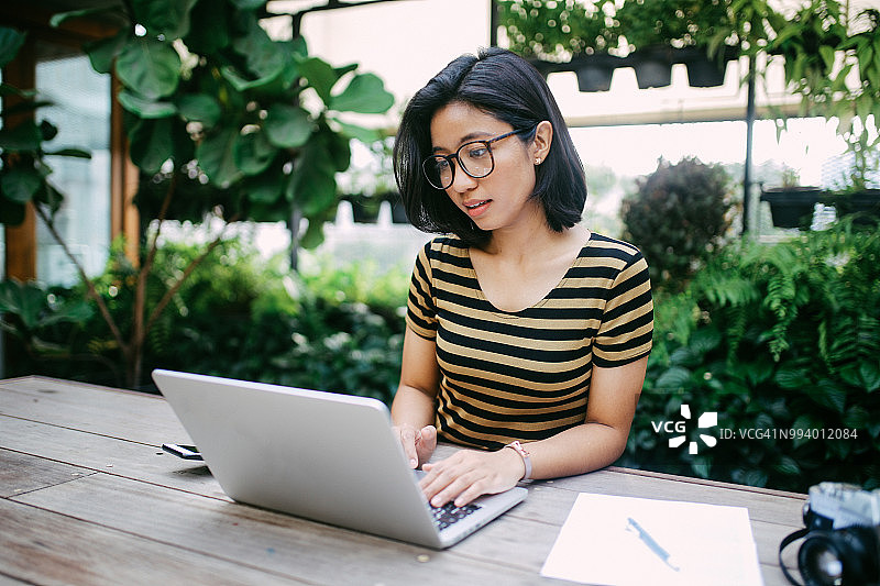 面带微笑的年轻亚洲自由职业女性完成工作图片素材