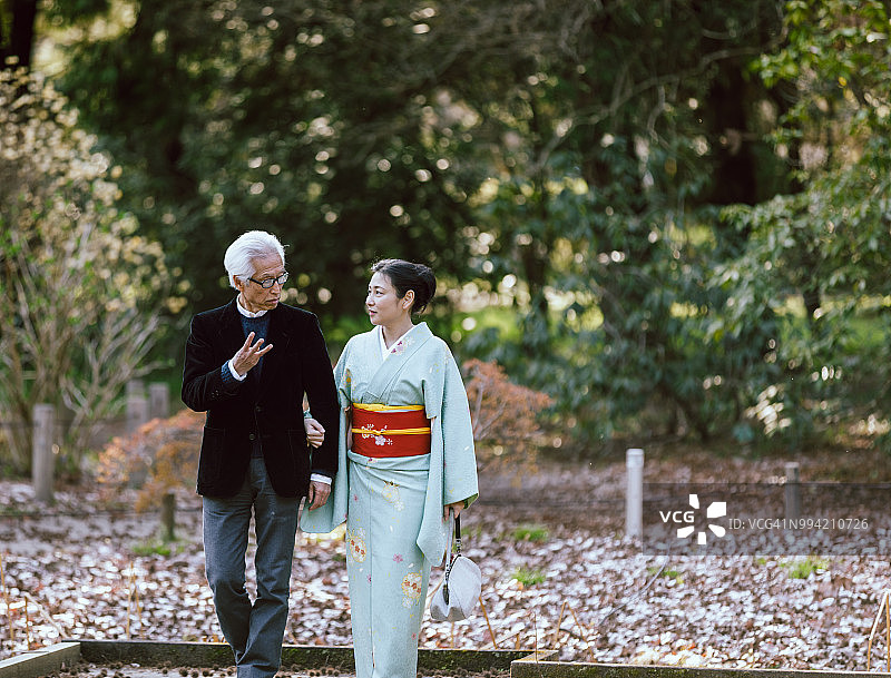 在公园里散步的银发老年亚洲夫妇图片素材