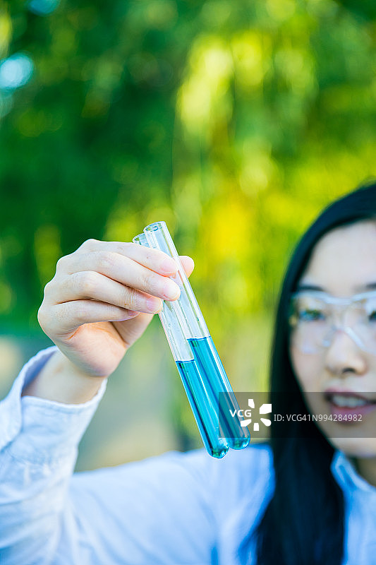 在户外做化学实验的年轻科学家图片素材