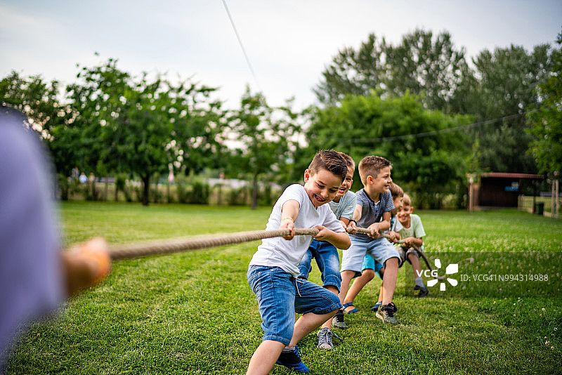 一群快乐的孩子在公园里拉绳子图片素材