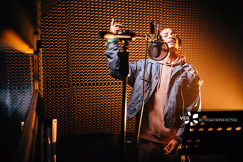 在录音棚录制歌曲的年轻时尚说唱歌手图片素材