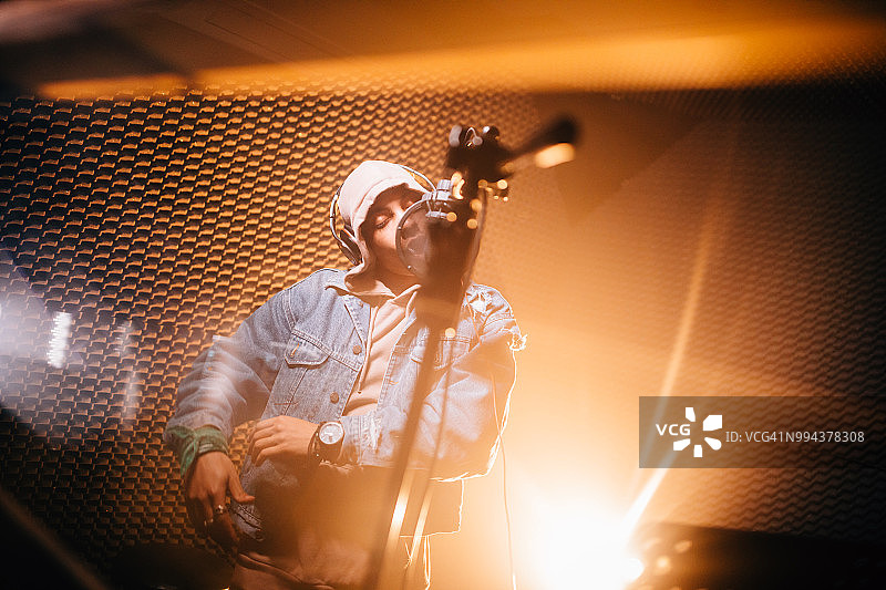 在专业音乐工作室录制歌曲的年轻潮男音乐家图片素材