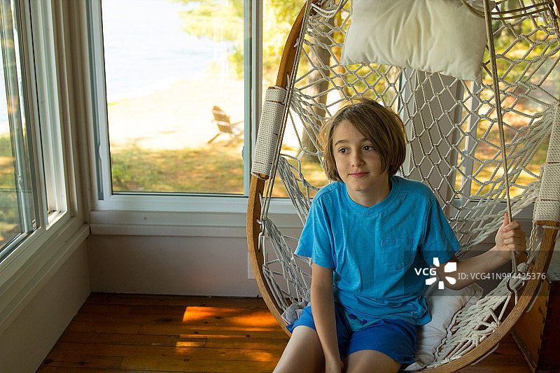 坐在摇椅上的10岁男孩肖像图片素材