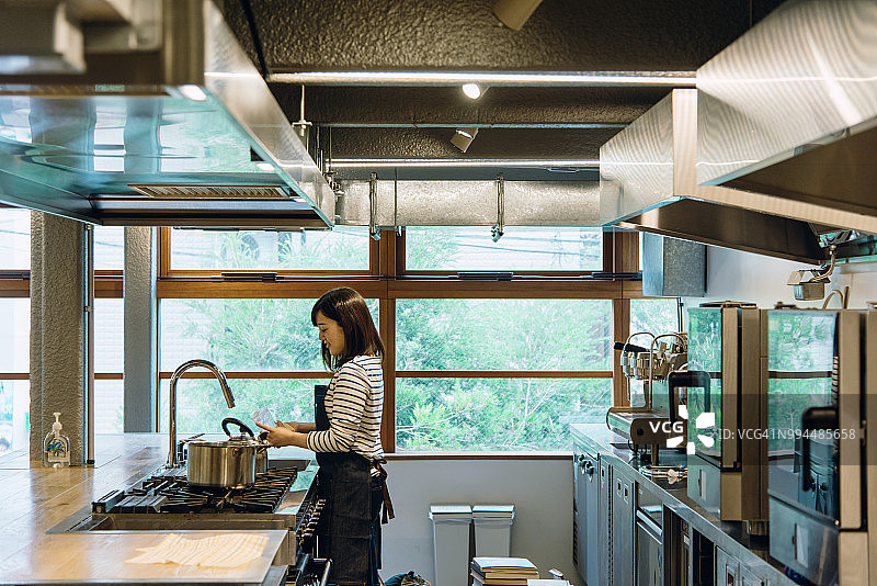 在厨房擦玻璃的年轻女人图片素材