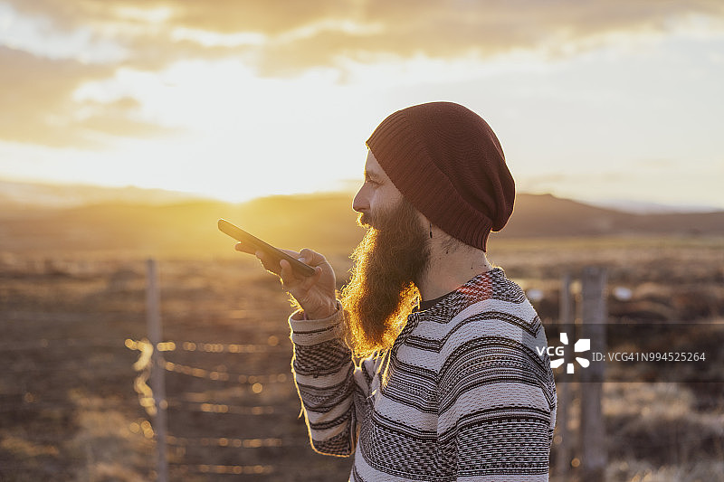 冰岛：正在使用智能手机语音消息的年轻人图片素材
