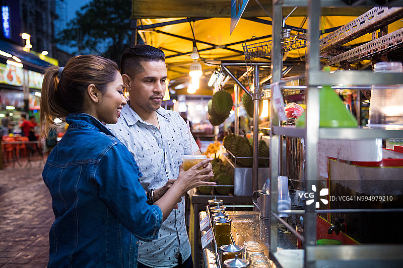 情侣在夜市品尝当地美食图片素材