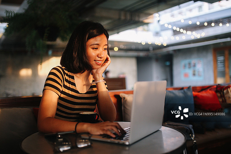 通过网络聊天的年轻亚洲自由职业者图片素材