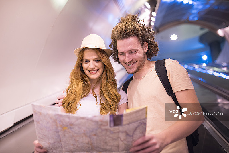 年轻情侣微笑地看着地图图片素材