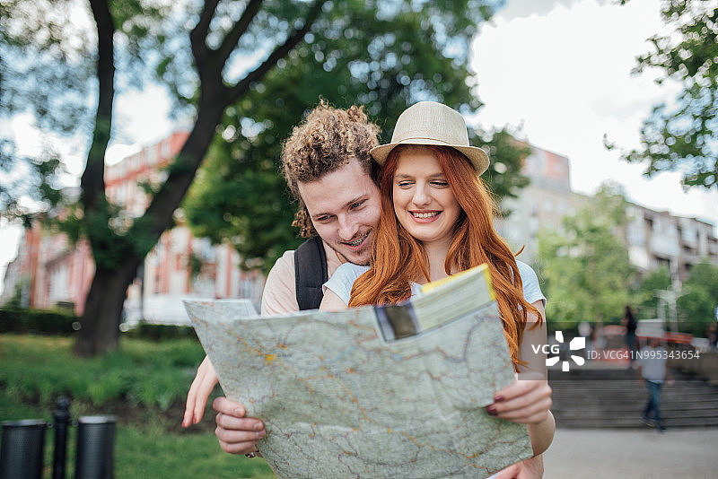 年轻男子拥抱手持地图的女子图片素材