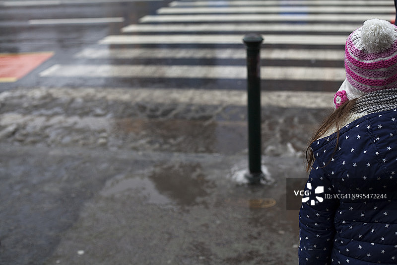 戴着羊毛帽的儿童站在街边图片素材