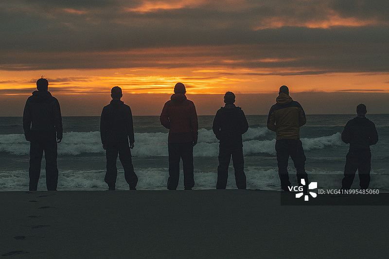 挪威罗弗敦莫斯克内斯岛日落时分站在布内斯海滩的年轻人图片素材