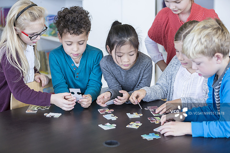小学生一起在学校玩拼图图片素材