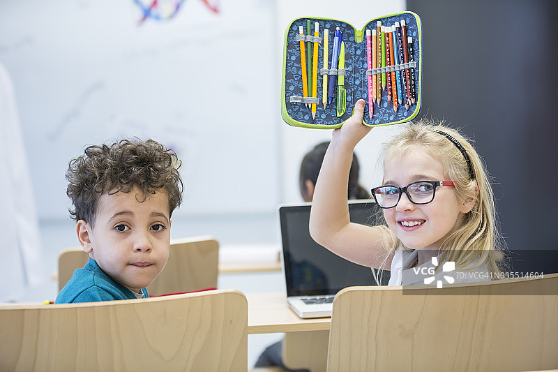 课堂上使用笔记本电脑和铅笔盒的男女学生肖像图片素材