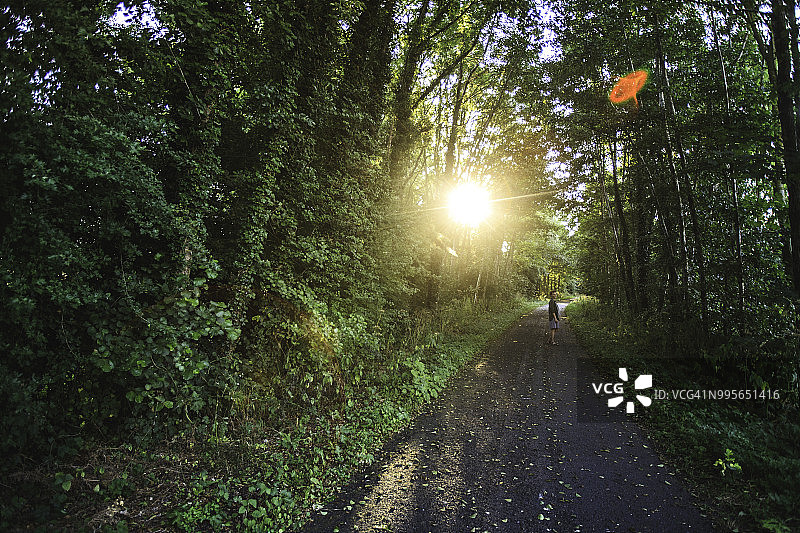 日落时分，女人走在诺曼底奥斯莫伊-圣瓦莱里附近的绿道上图片素材