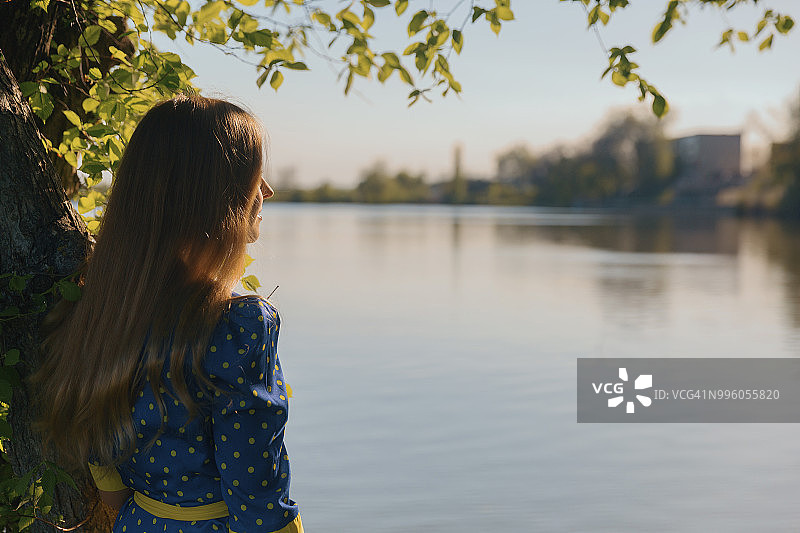 望着河流的金发长发女人图片素材