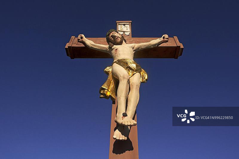 德国巴登-符腾堡林斯海姆的彩色石制十字架与蓝天图片素材