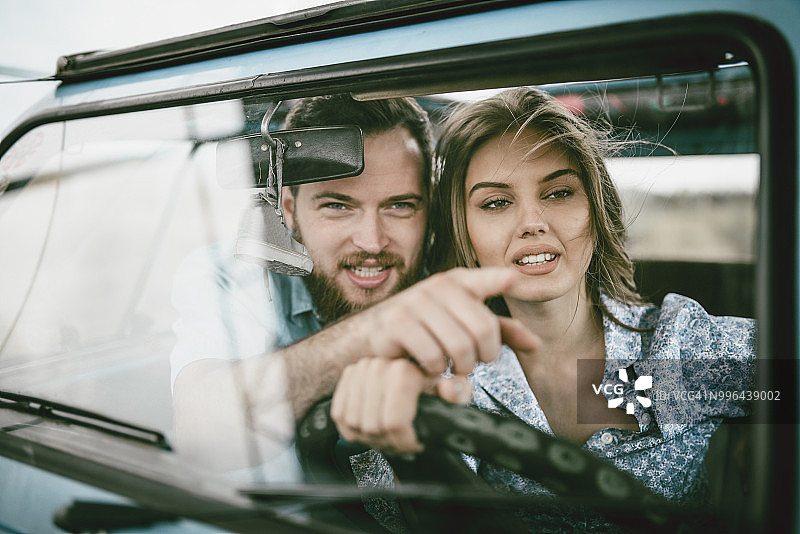 异性恋夫妇乘坐老爷车前往目的地图片素材