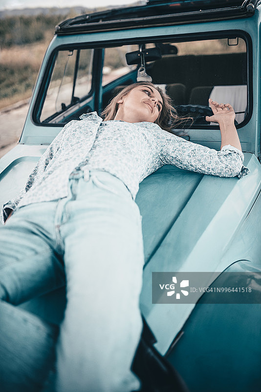 躺在汽车引擎盖上的女子图片素材